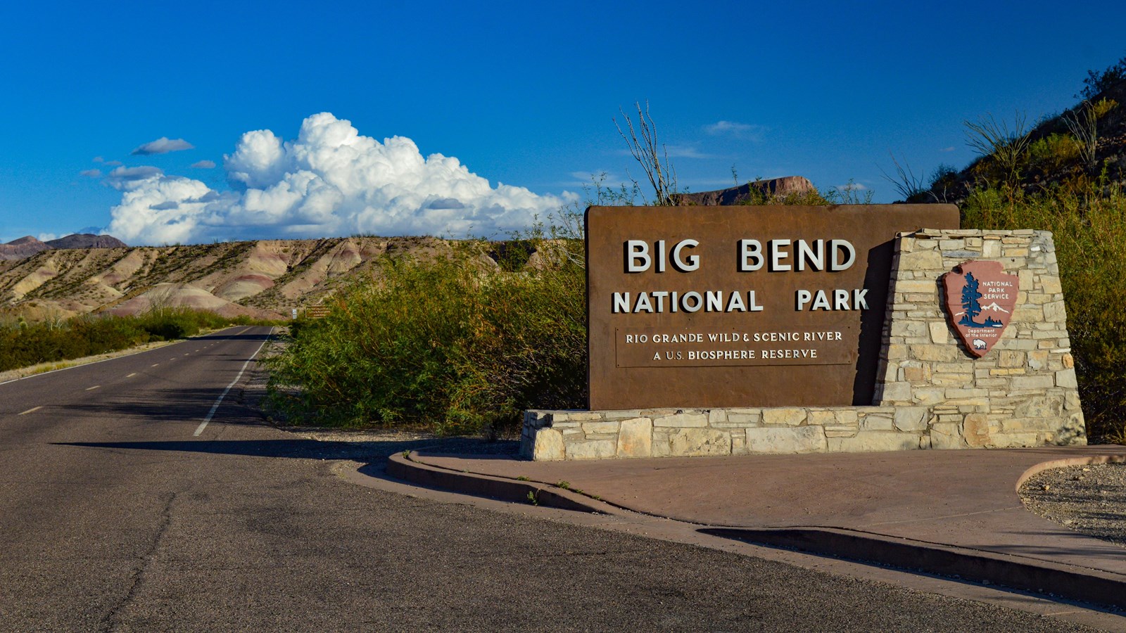 A stone and concrete sign with Big Bend\'s title sits adjacent to a paved vehicle pullout.