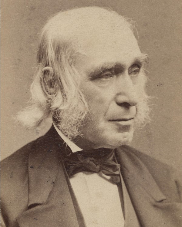 Portrait of Bronson Alcott, an old White man who has white thin hair and wears a suit.