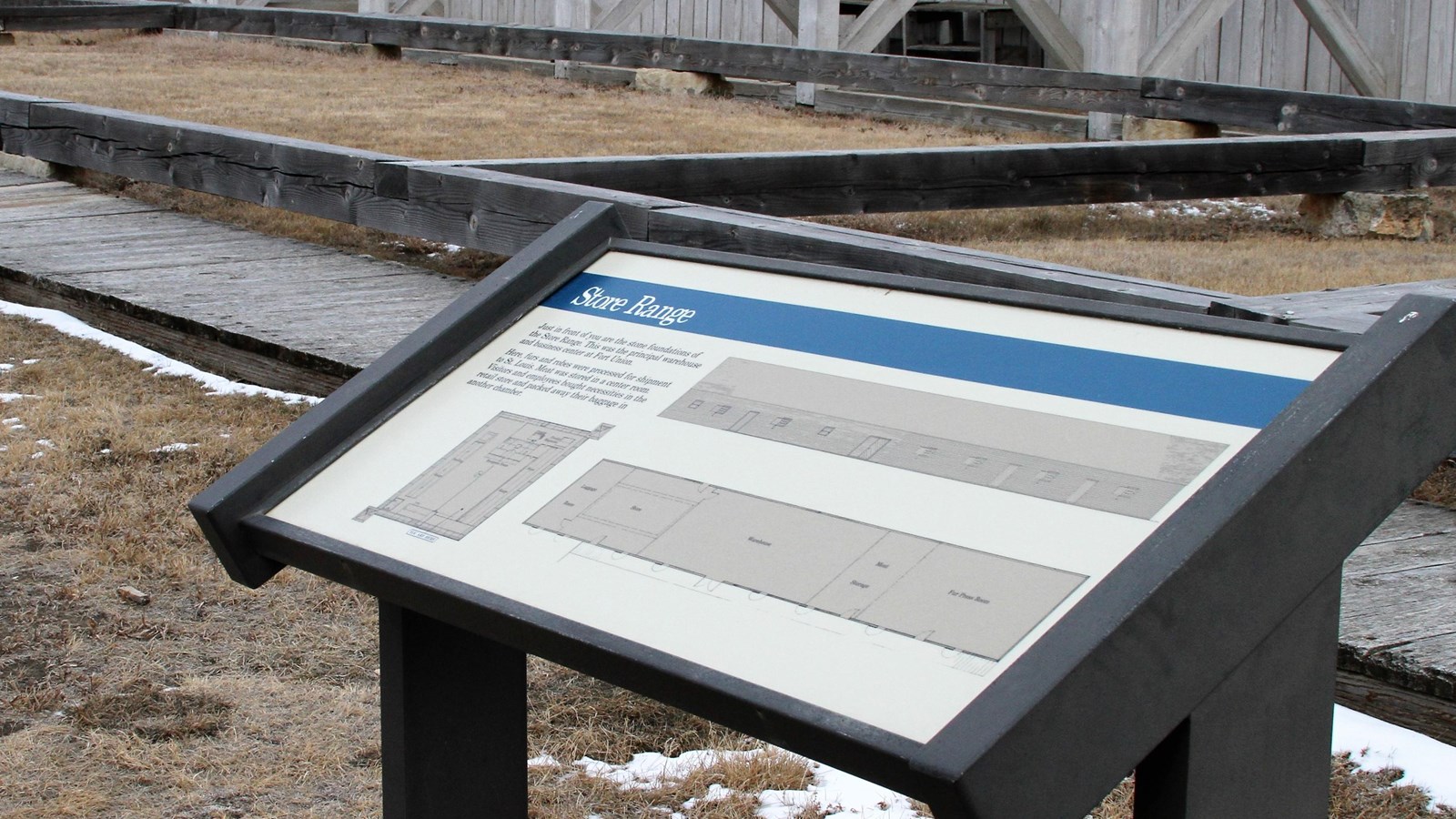 Panel with line-drawing of Store Range stands in front of wooden beams supported by flagstones