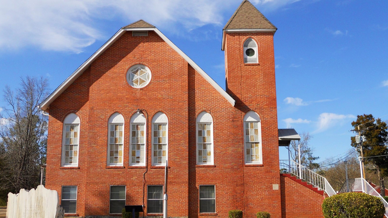 Photo of brick church with spire. By Rivers A. Langley, CC BY-SA 3.0. 