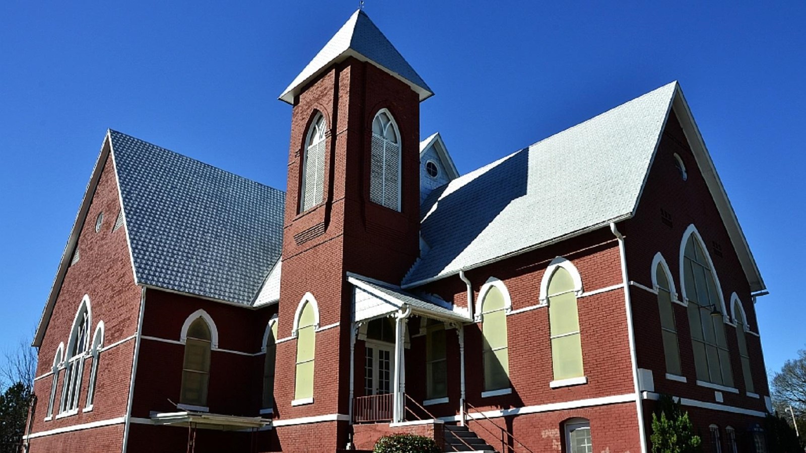 Large brick church with pointed spire. Photo by Richard apple, CC BY-SA 3.0.