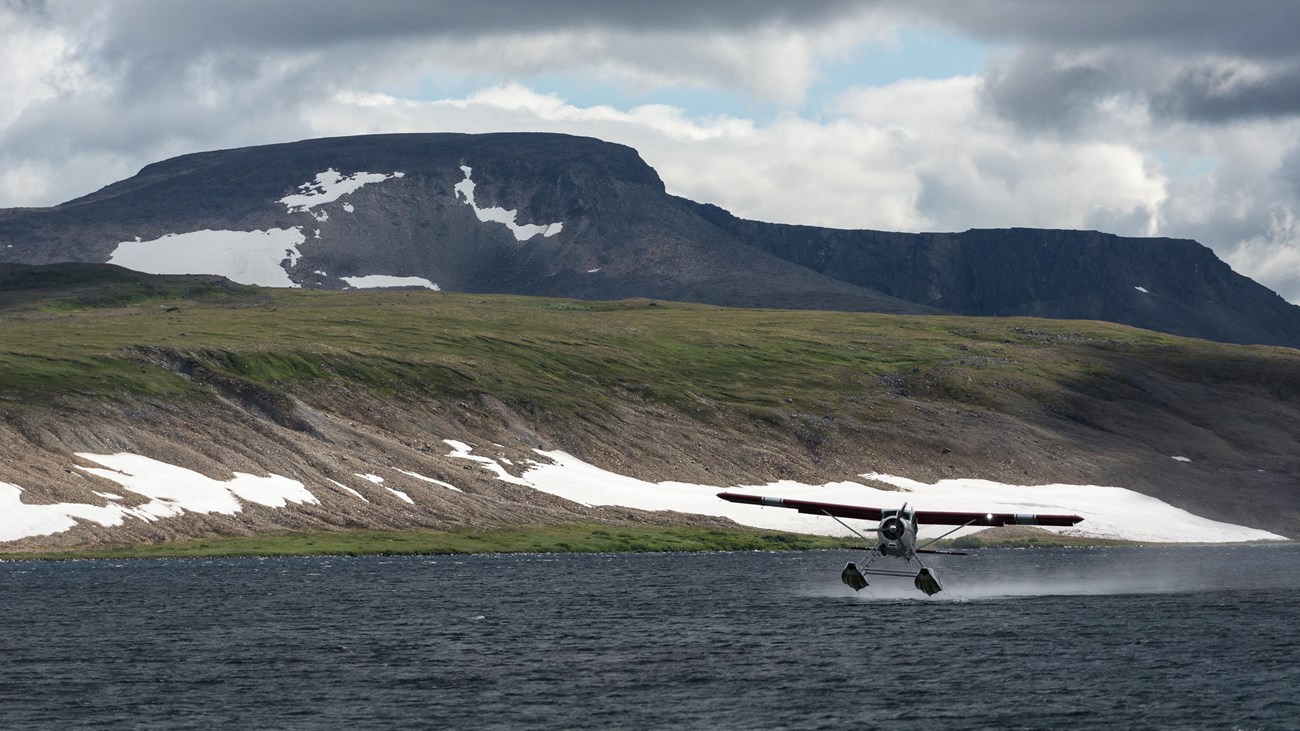 Float plane landing on the water on a cloudy day