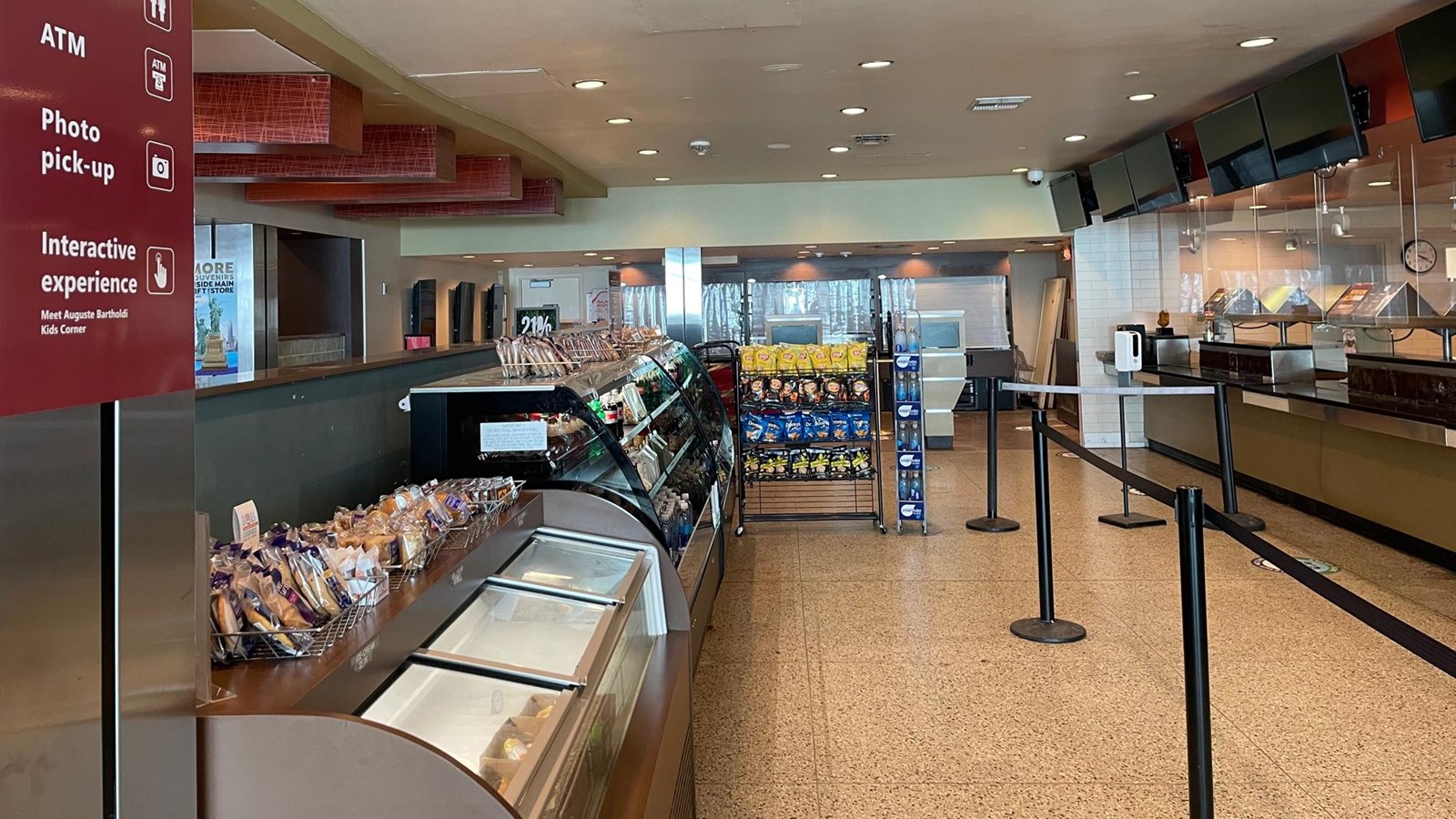 Room with refrigerators with ice cream and shelves with snacks, a counter for ordering food