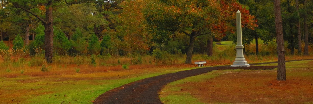 Fall scene with walking trail and monument in the background