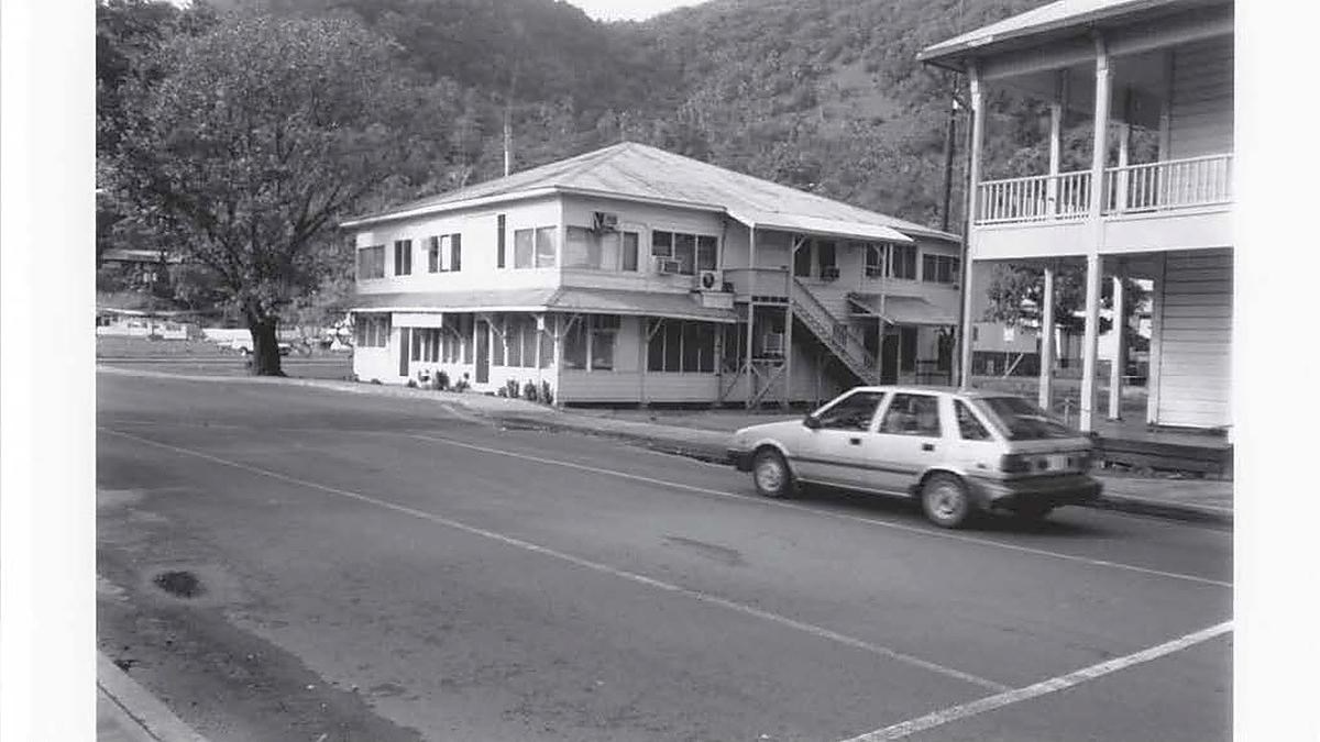 Black and white photo, 2 story building set off the main road