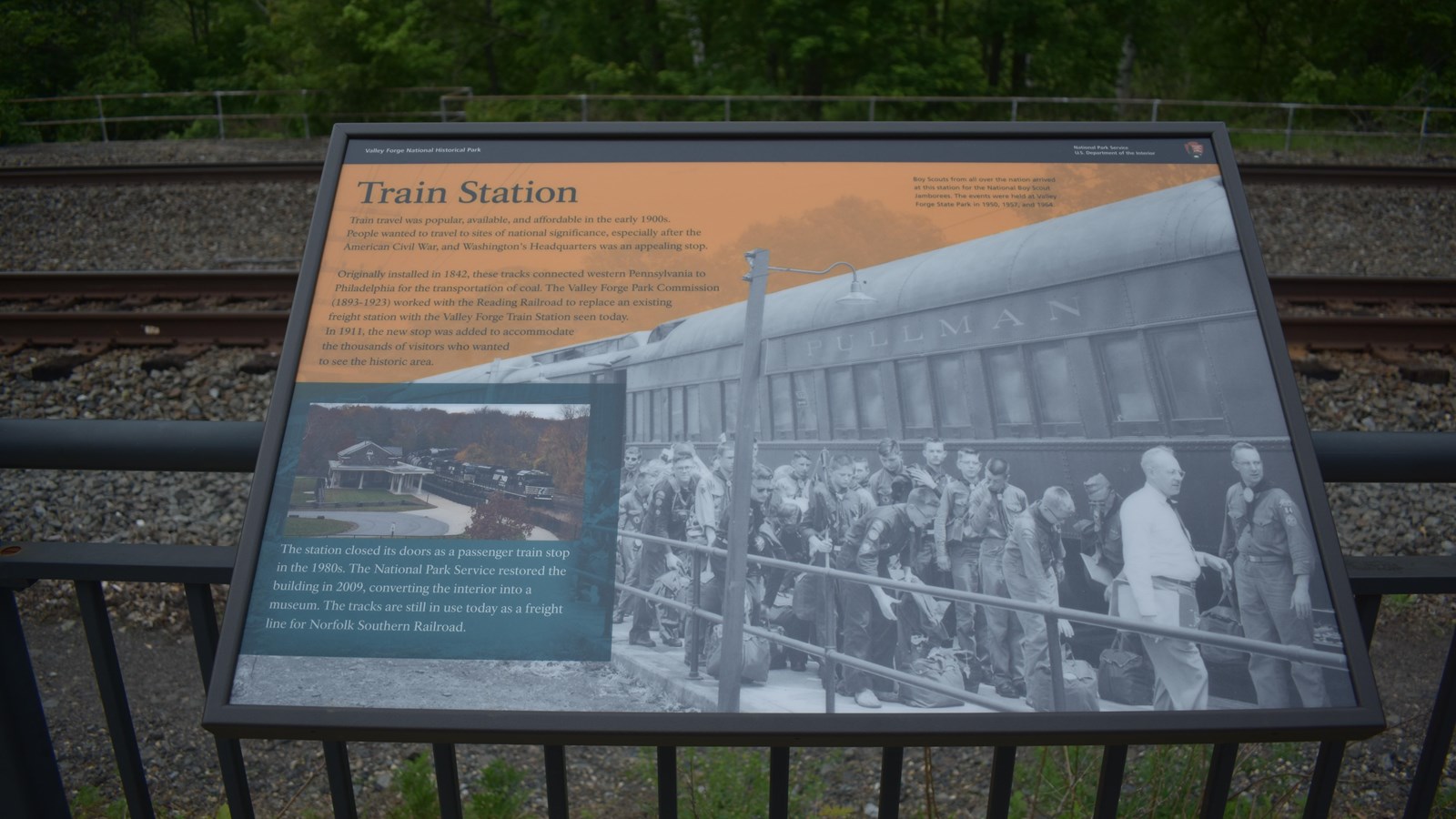 wayside exhibit panel with historic photo of boy scouts disembarking from a train.