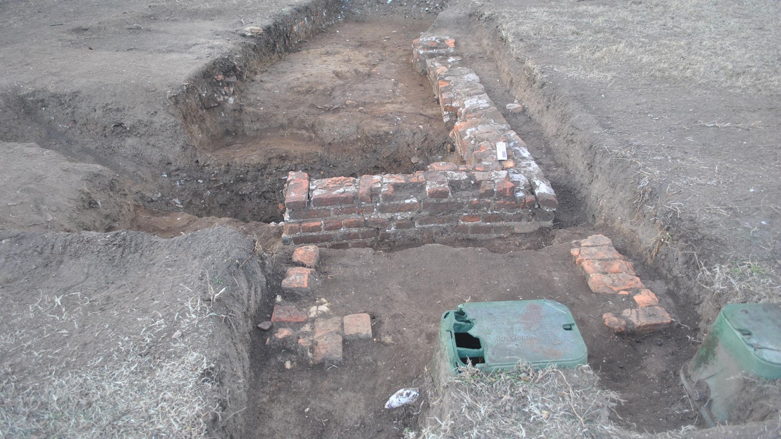 An excavation site with an uncovered brick foundation.