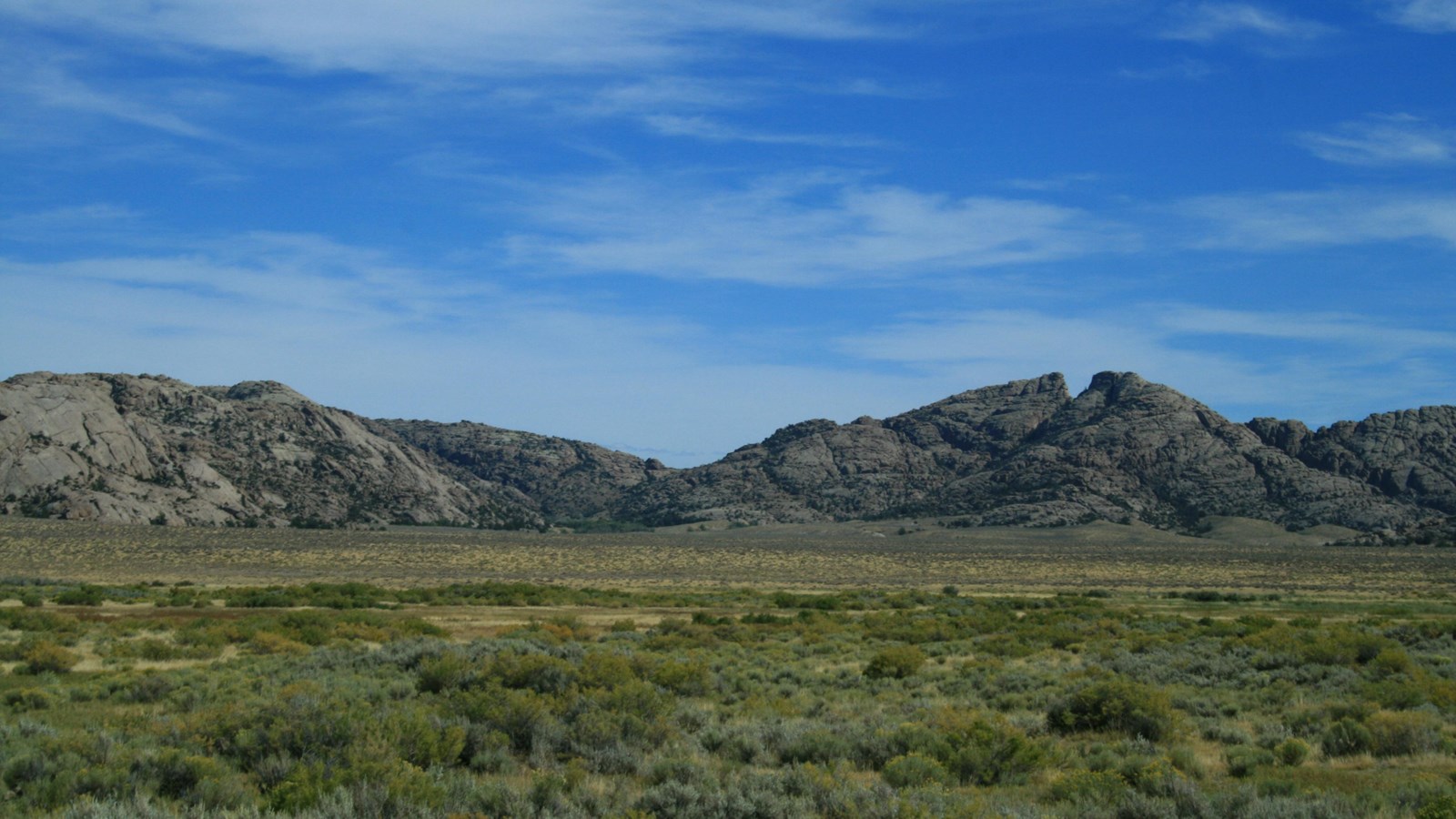 Distant stone mountains, with a cleft appearing in the top of the right landmark.