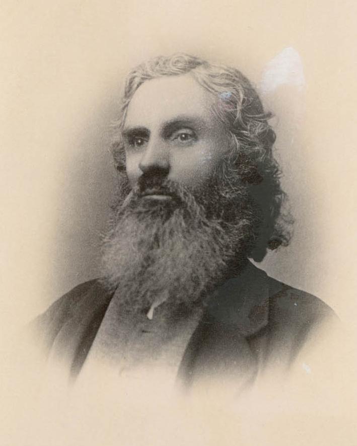 Portrait of a man with a long thick beard looking off slightly into the distance