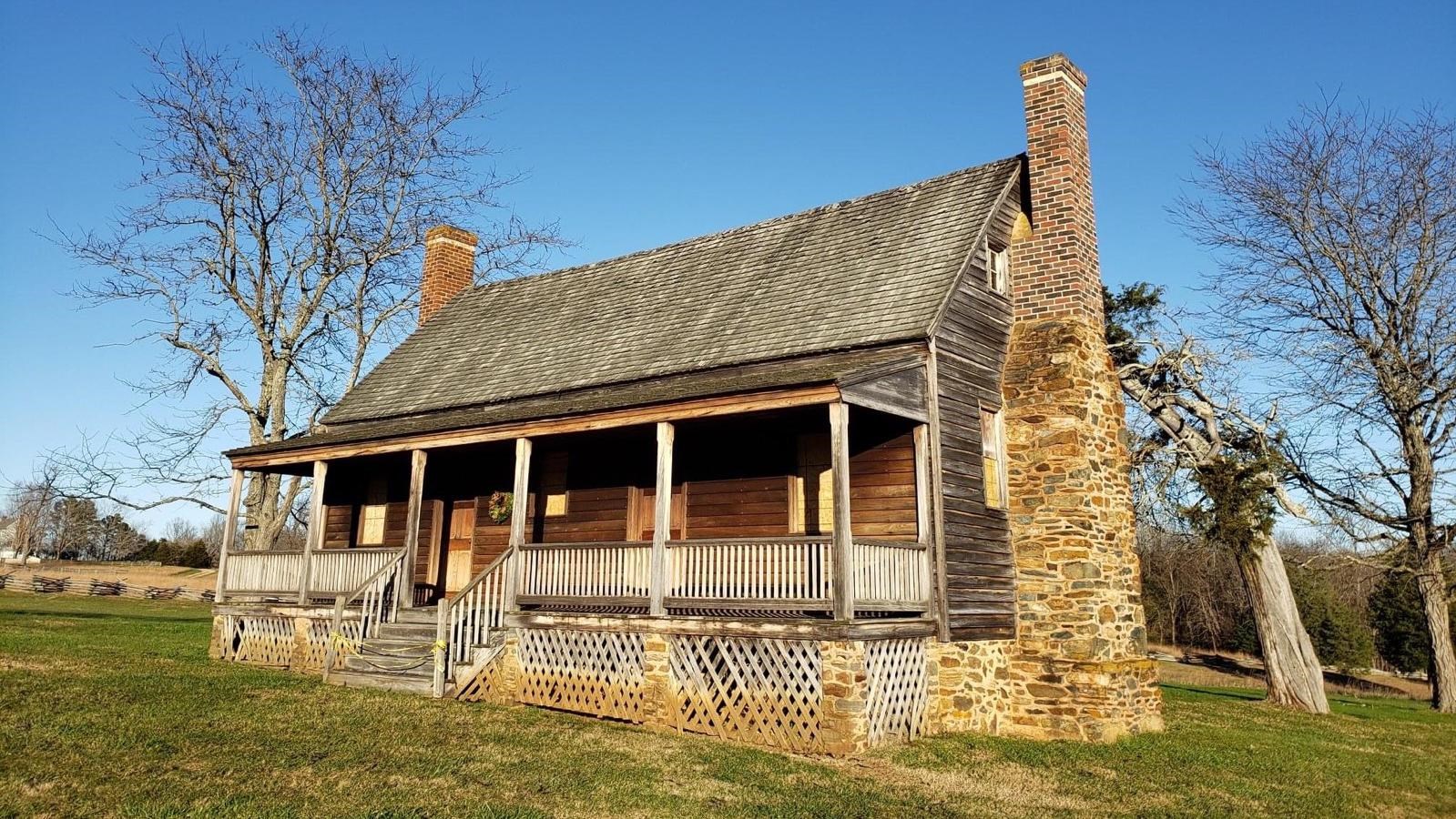A one and a half story wooden frame house with a large, covered porch on the front.