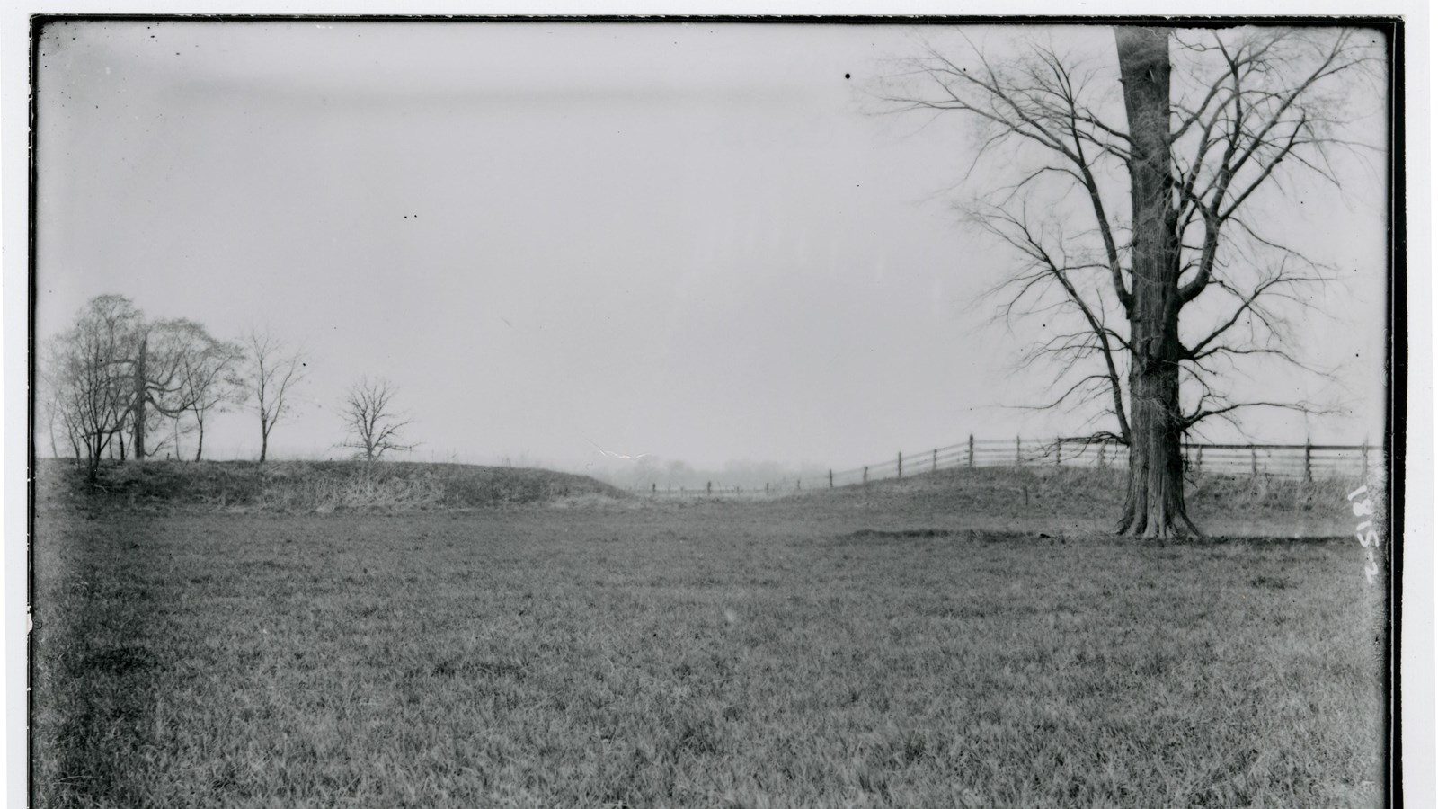 Black and white image of plowed over earthworks.