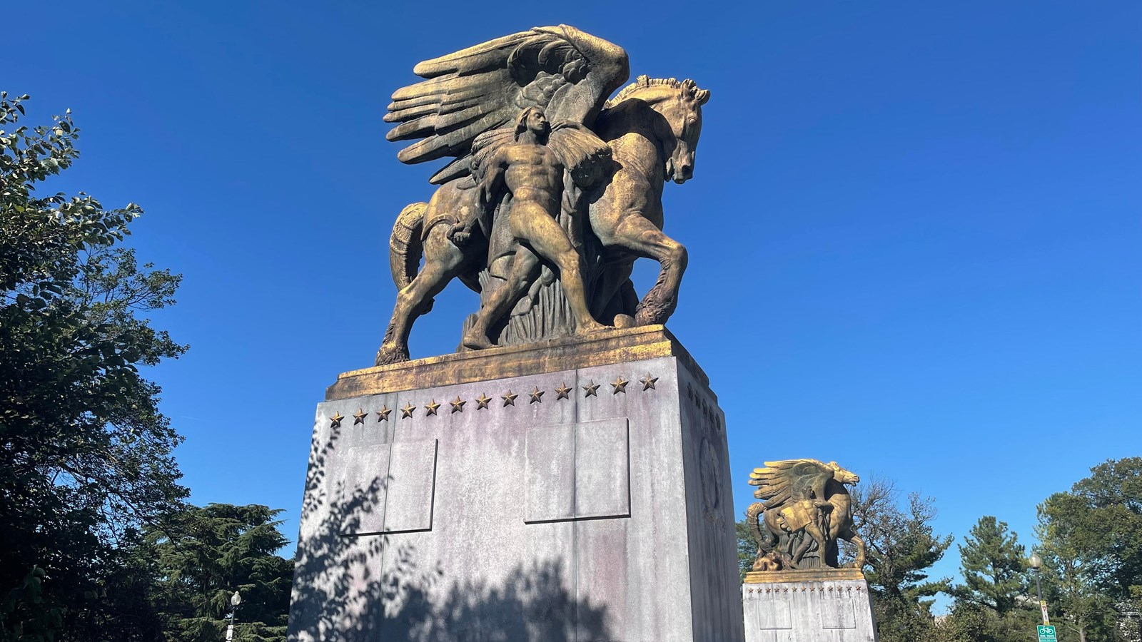 Large statue of a man and a horse on a tall pedestal