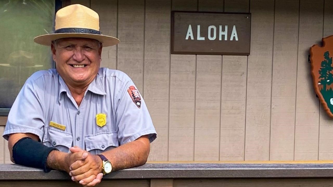 Ranger in flat hat stands in front of 