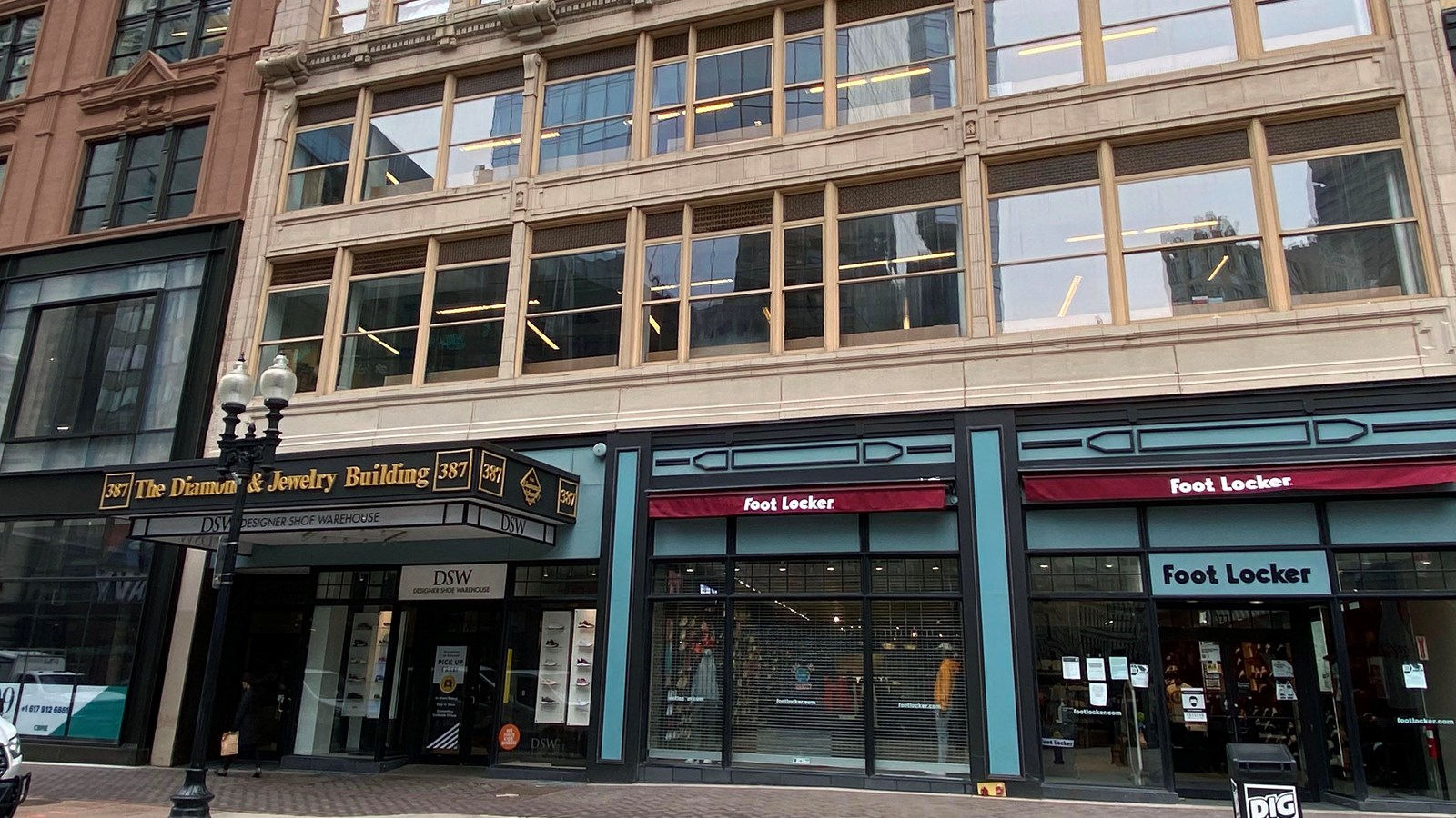 Multi-story building with large windows on the upper floors and store fronts on the bottom floor.