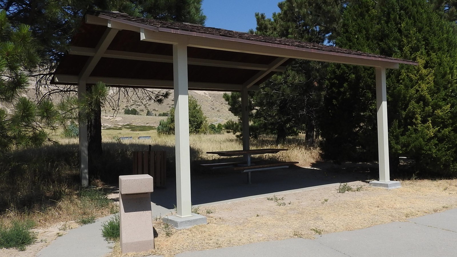 A picnic table sits under a roof