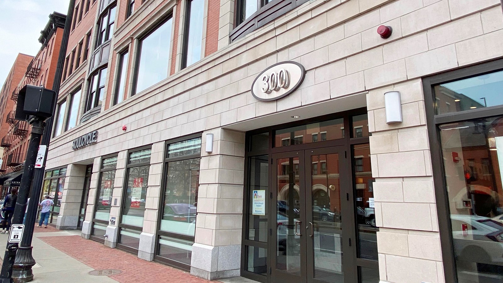 Angle view of a store front of a brick and stone building that is 4-5 stories tall.