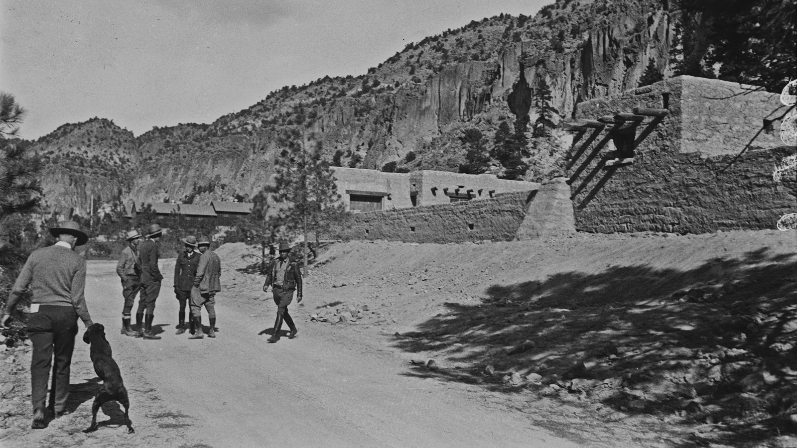 men in ranger uniforms look on while stone buildings are constructed
