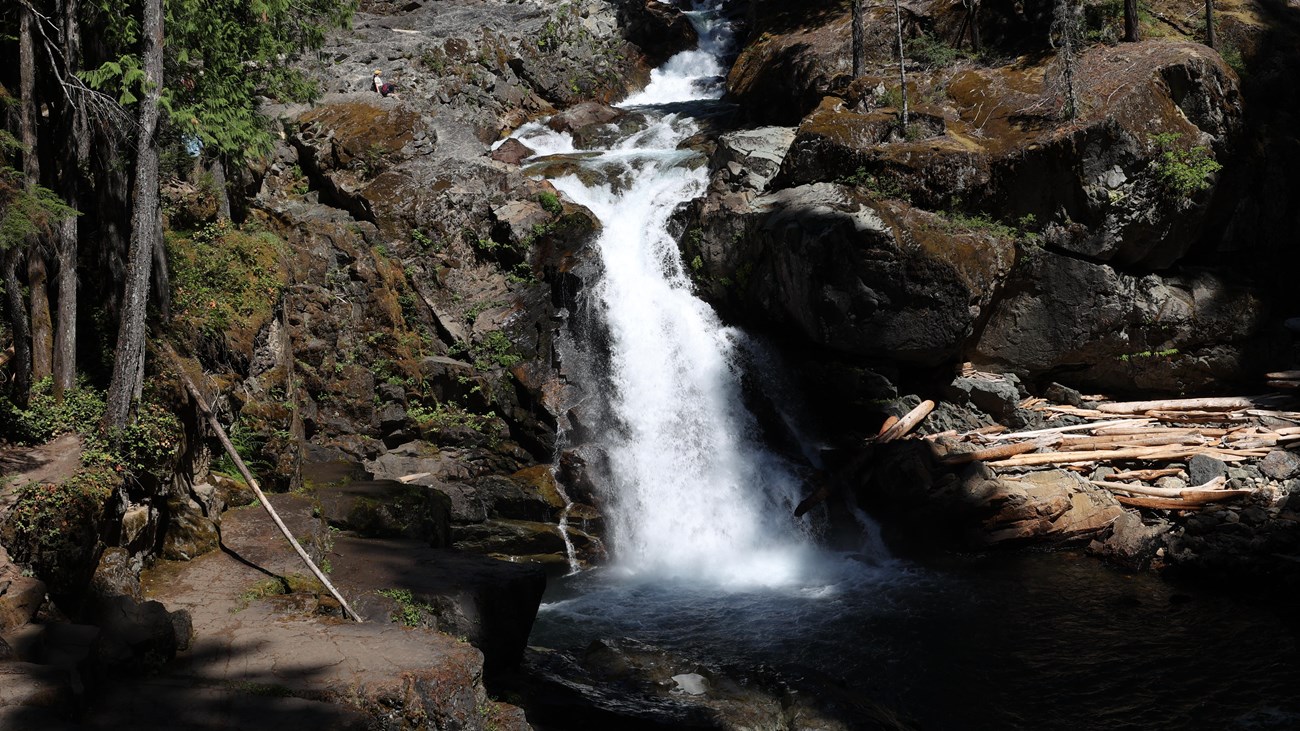 A cascading waterfall flows over steep rocks