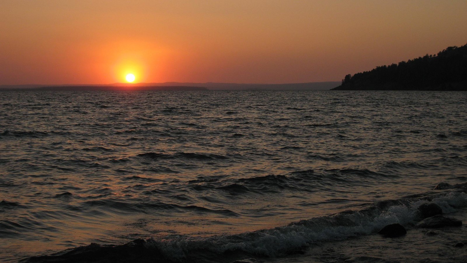 Sun rising over the waters of Yellowstone Lake.