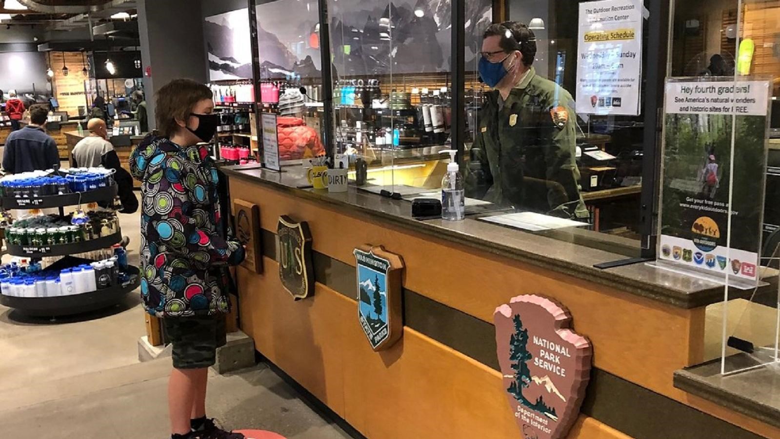 Person in ranger uniform talking with visitor