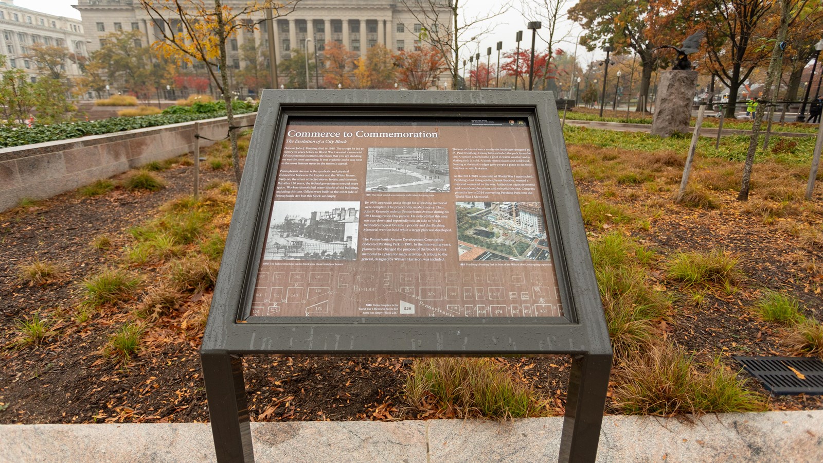 Information panel in front of a planted garden area.