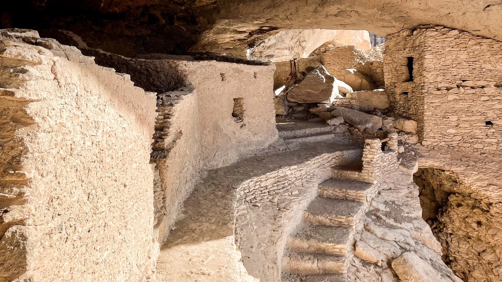 Narrow stone walkway with a two-story building in the background.