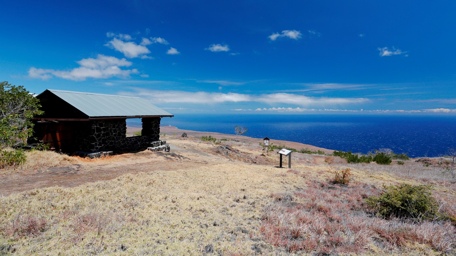 A stone shelter on a hillside overlooking the ocean