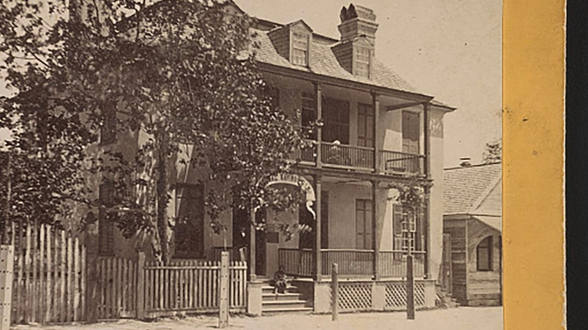 A multistory brick building with a store front on the first floor. 