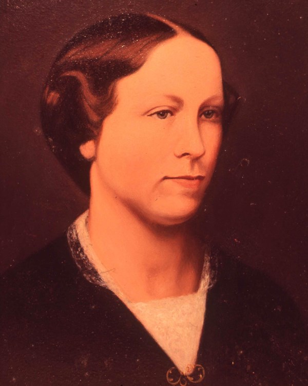 A portrait of a woman's with short hair a black top and a white lace collar. 