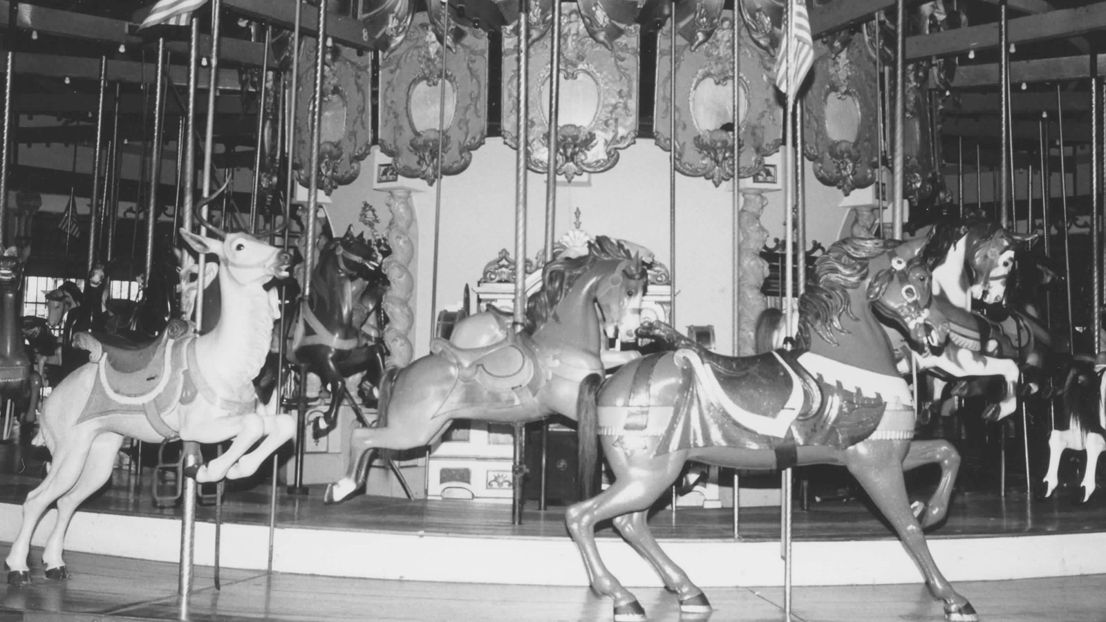 Carousel with various carved horses and a carved deer