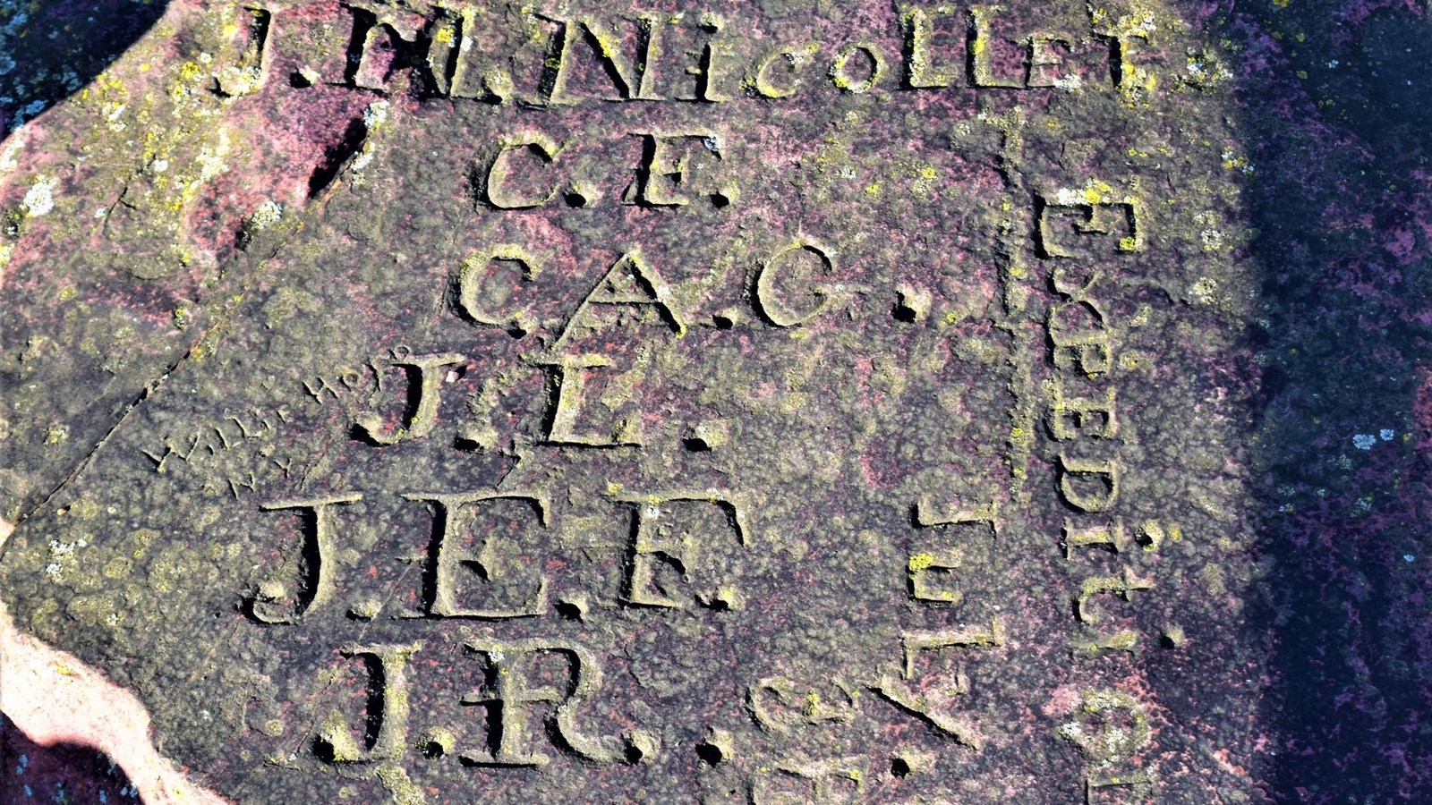 A stone with initials and a date carved into them