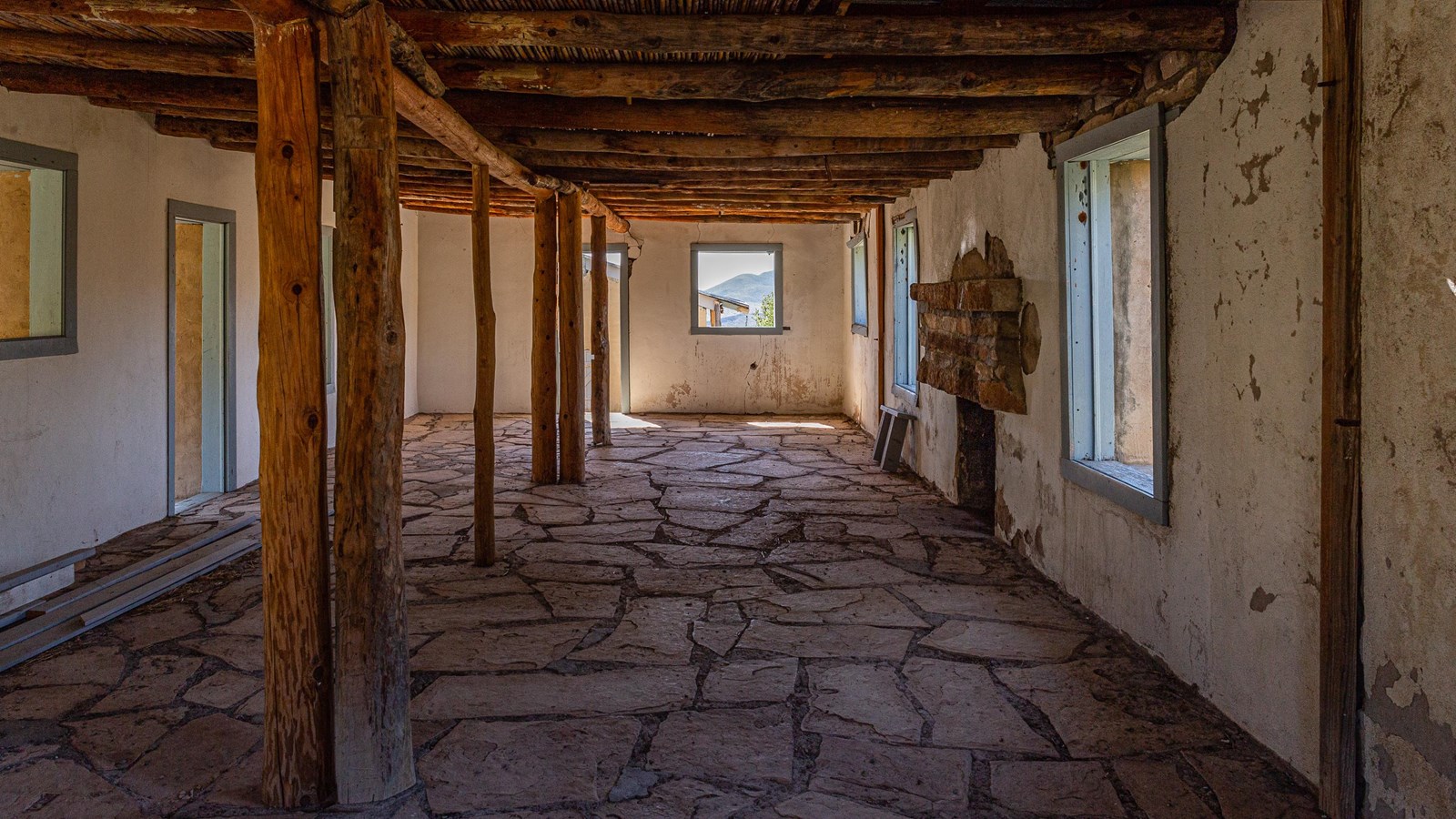 Interior of line camp with flagstone floor, reed ceiling, and white-washed stucco walls.
