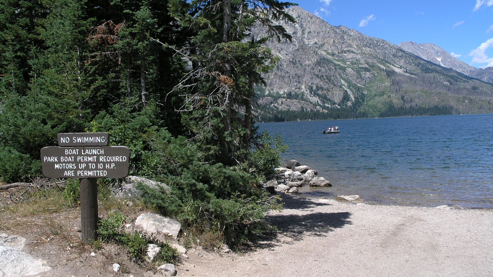 Jenny Lake Boat Launch with sign and views of Jenny Lake.