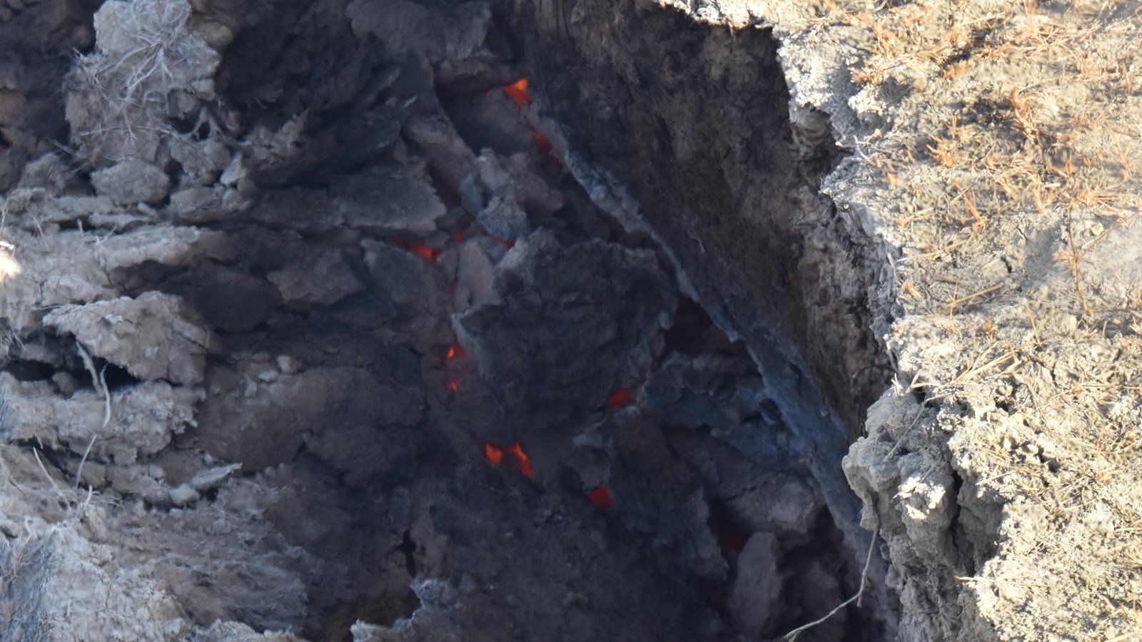 Glowing coals are visible through clay.