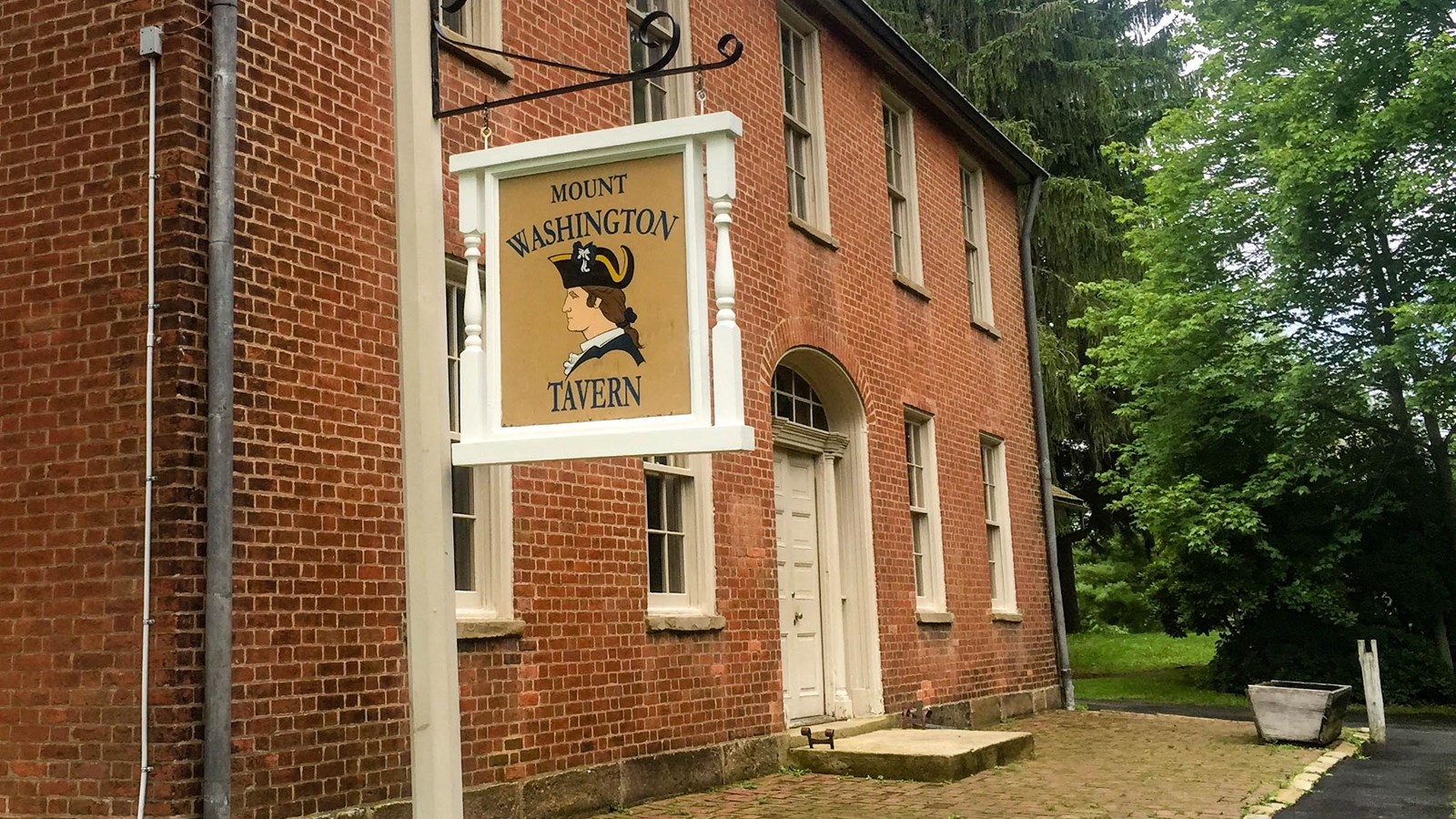 Two story brick building with a sign in fornt