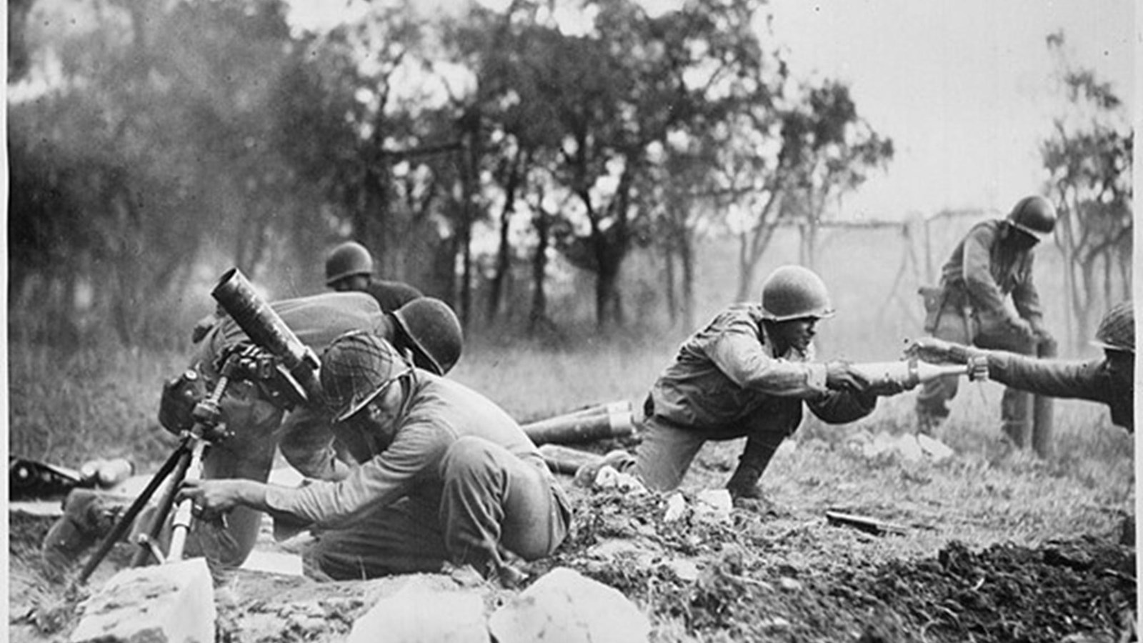 Several uniformed men loading weapons