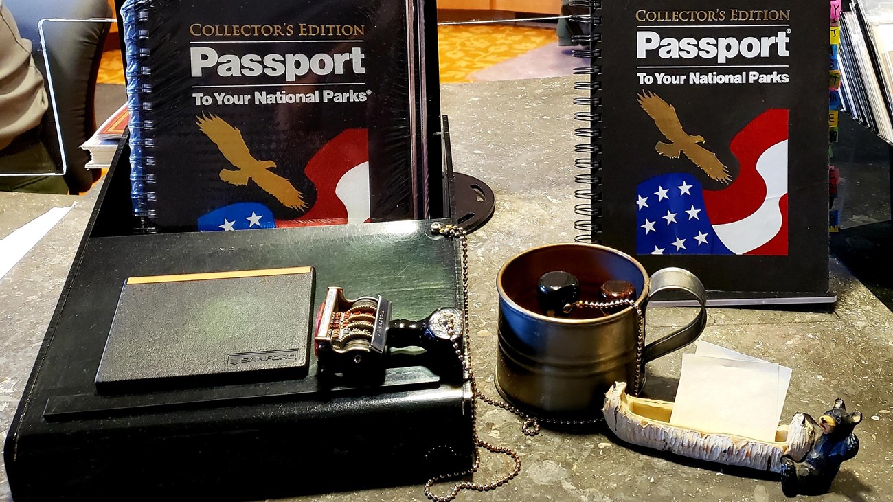 Desktop display with National Parks passport books and date stamp.