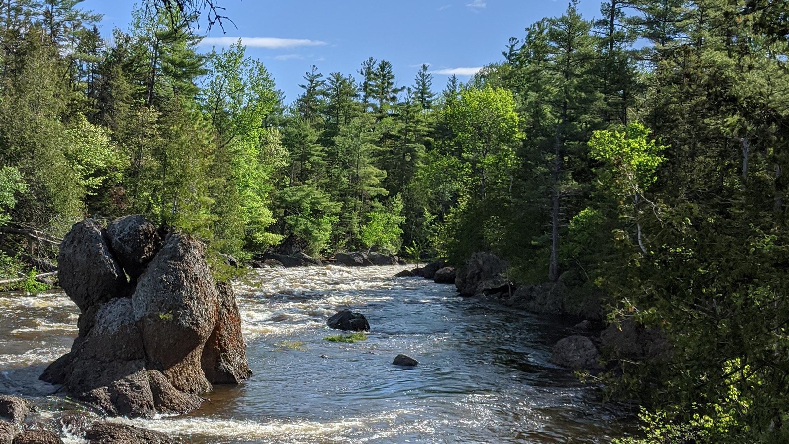 A rounded stone pillar approximately 20 feet protrudes from the East Branch Penobscot River.