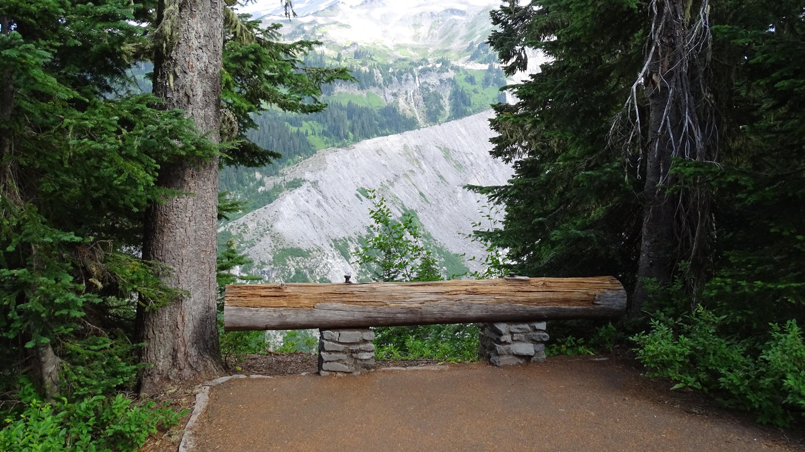 An overlook bordered on one sides by low log railing. Nisqually valley is in the distance.
