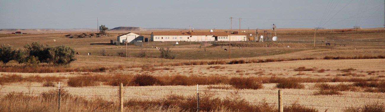 View of a ranch-style building inside a fenced compound