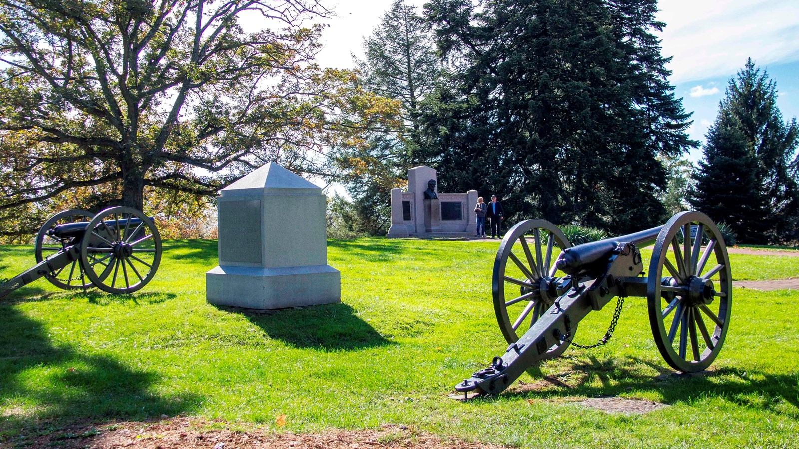 Two cannons flanking a monument in a cemetery