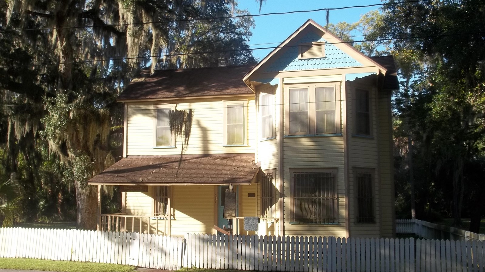 Two-story home surrounded by palm trees. Photo by Ebyabe, CC BY-SA 4.0