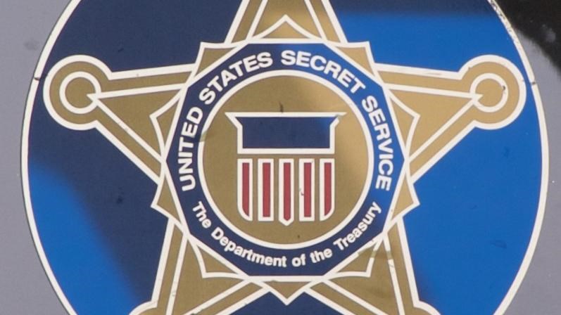 A five-pointed star on a blue circle background represents the Secret Service emblem.