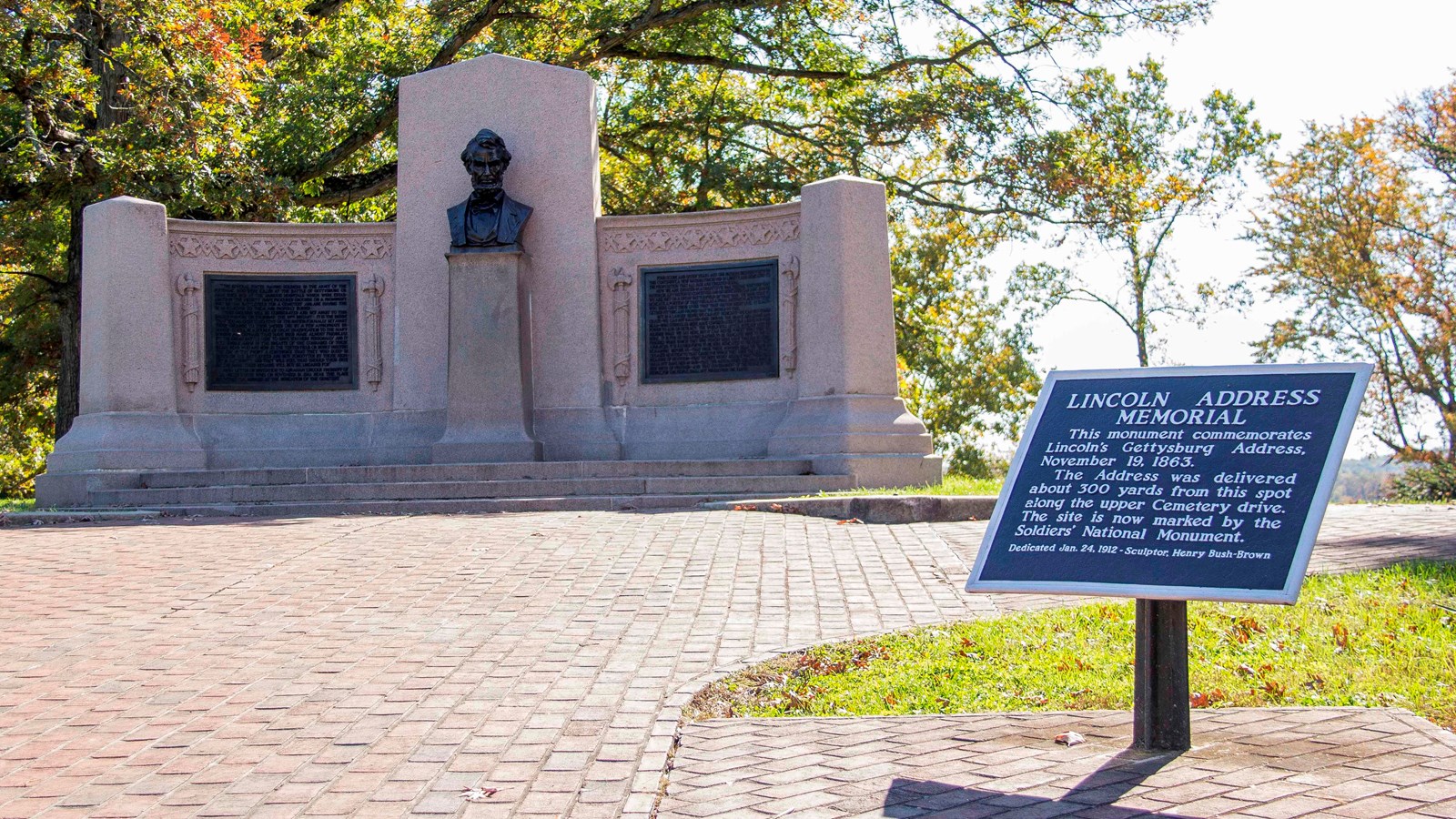 A large monument with a bust of Abraham Lincoln and two bronze plaques with the Gettysburg Adress