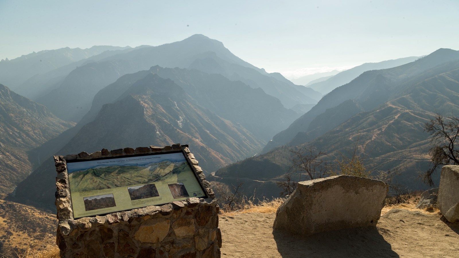 Metal sign labeling the mountain peaks in the background