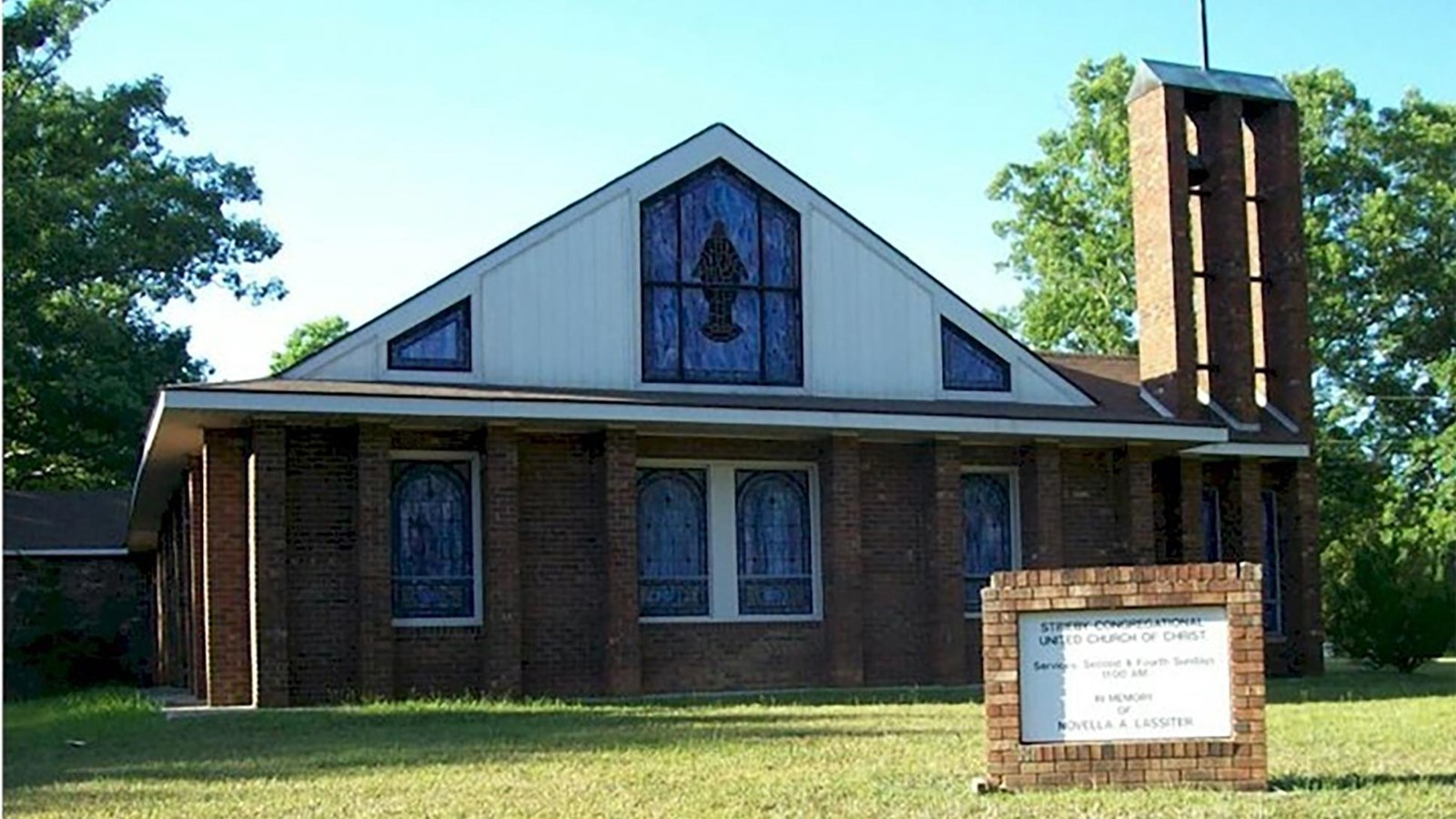 A one story brick church with stained glass windows