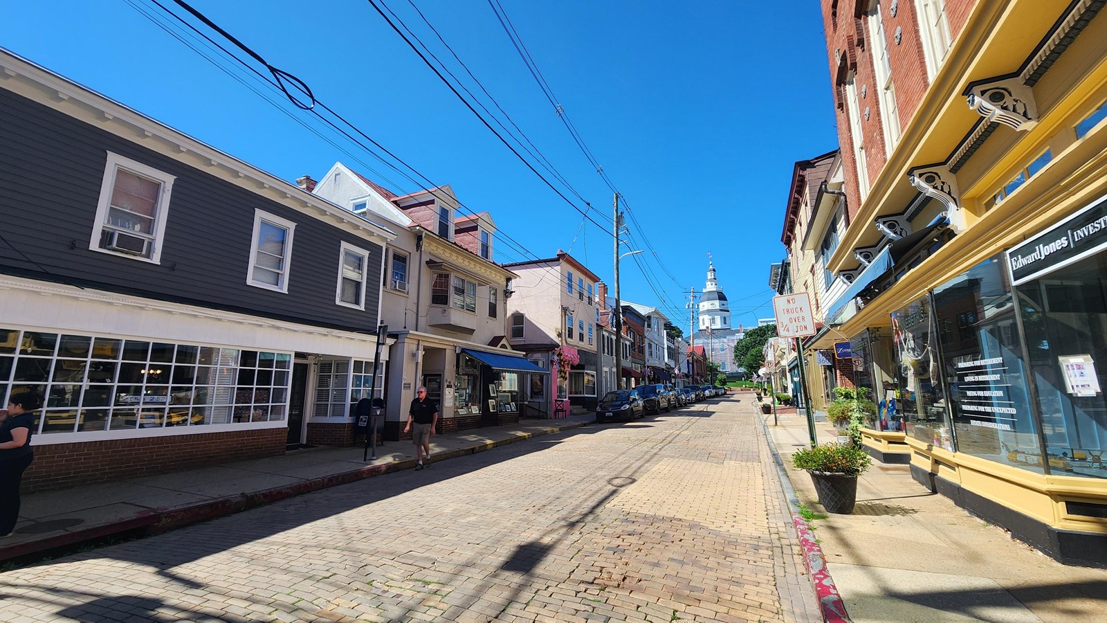 Maryland Avenue is a brown cobblestone street flanked by wooden, stucco, and brick storefronts.