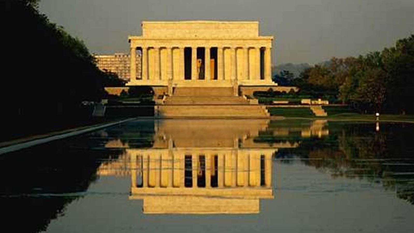 Monument with columns reflected in a pool of water.