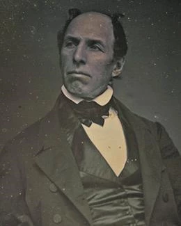 Balding middle-aged man in 1800s clothing.