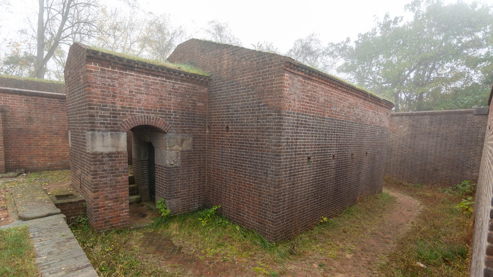 A small rectangular brick building with a doorway jutting from the front